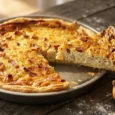 Tarte à l'oignon alsacienne dorée, une part découpée montrant la garniture crémeuse aux lardons